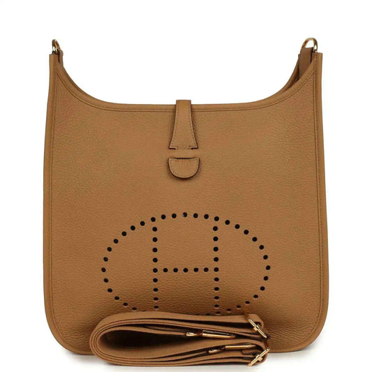 Tan leather hobo bag with perforated logo, snap tab, and gold hardware