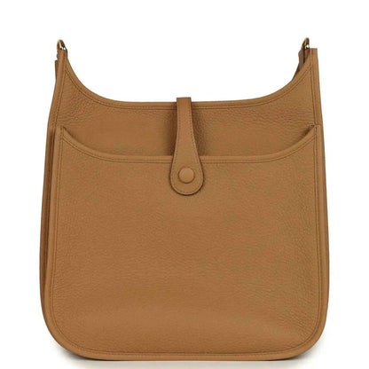 Tan leather hobo bag with front pocket, snap closure, and gold-tone hardware
