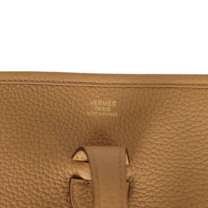 Tan leather bag close-up with Hermes Paris Made in France stamp and strap hardware