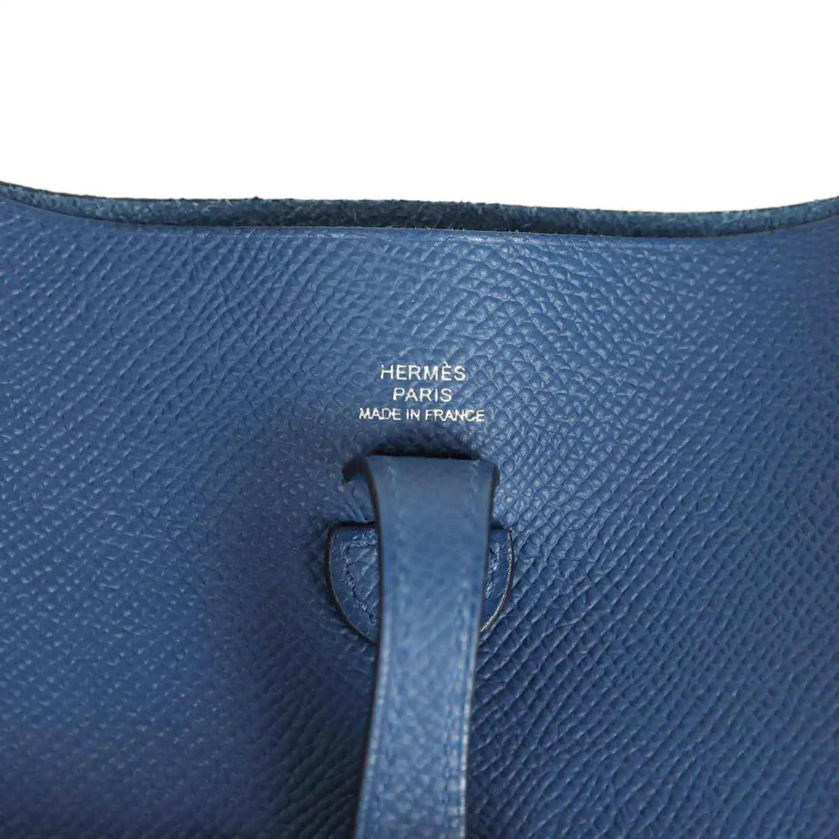 Blue leather bag interior label with Hermes text on textured Epsom surface