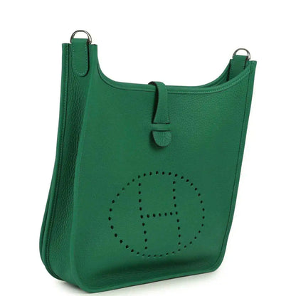 Green leather crossbody bag front with perforated logo and top handle