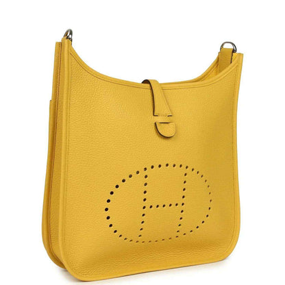 Yellow leather shoulder bag with perforated logo emblem and top handle strap