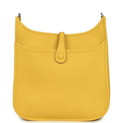 Yellow leather hobo bag with curved top, front flap, and central tab closure