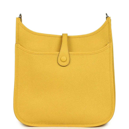 Yellow leather hobo bag with curved top, front flap, and central tab closure