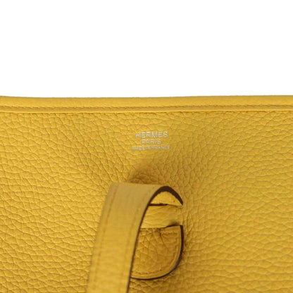 Hermès embossed yellow leather tab detail with strap and stitching