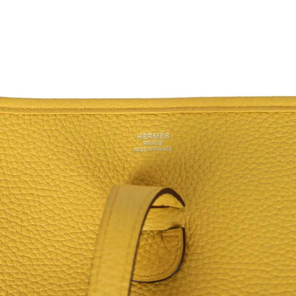 Hermès embossed yellow leather tab detail with strap and stitching