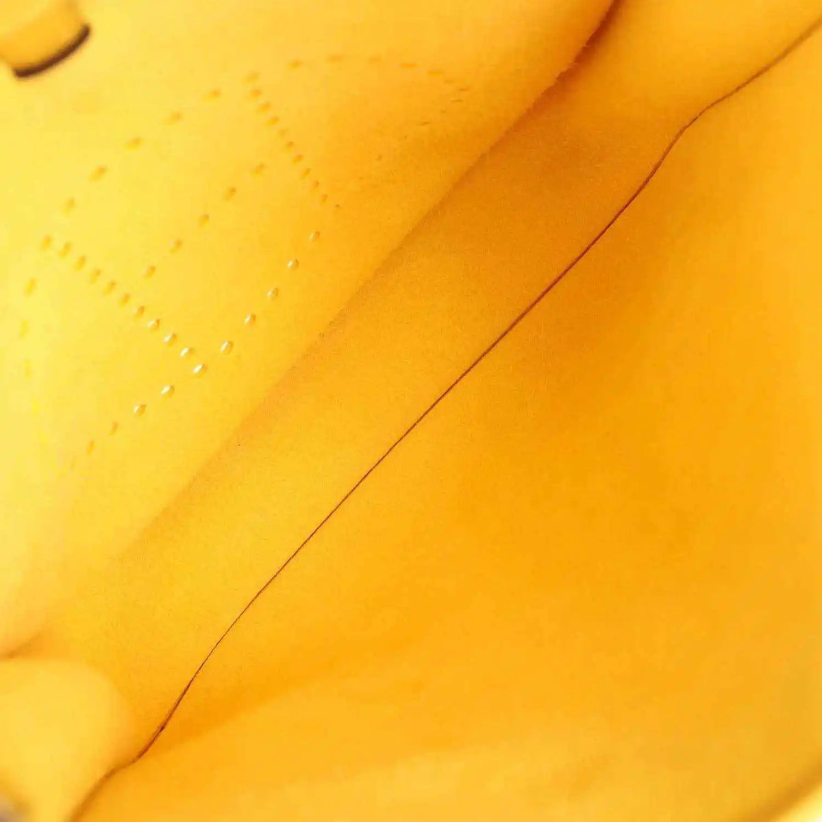 Yellow leather interior seam close-up with smooth finish and stitching line