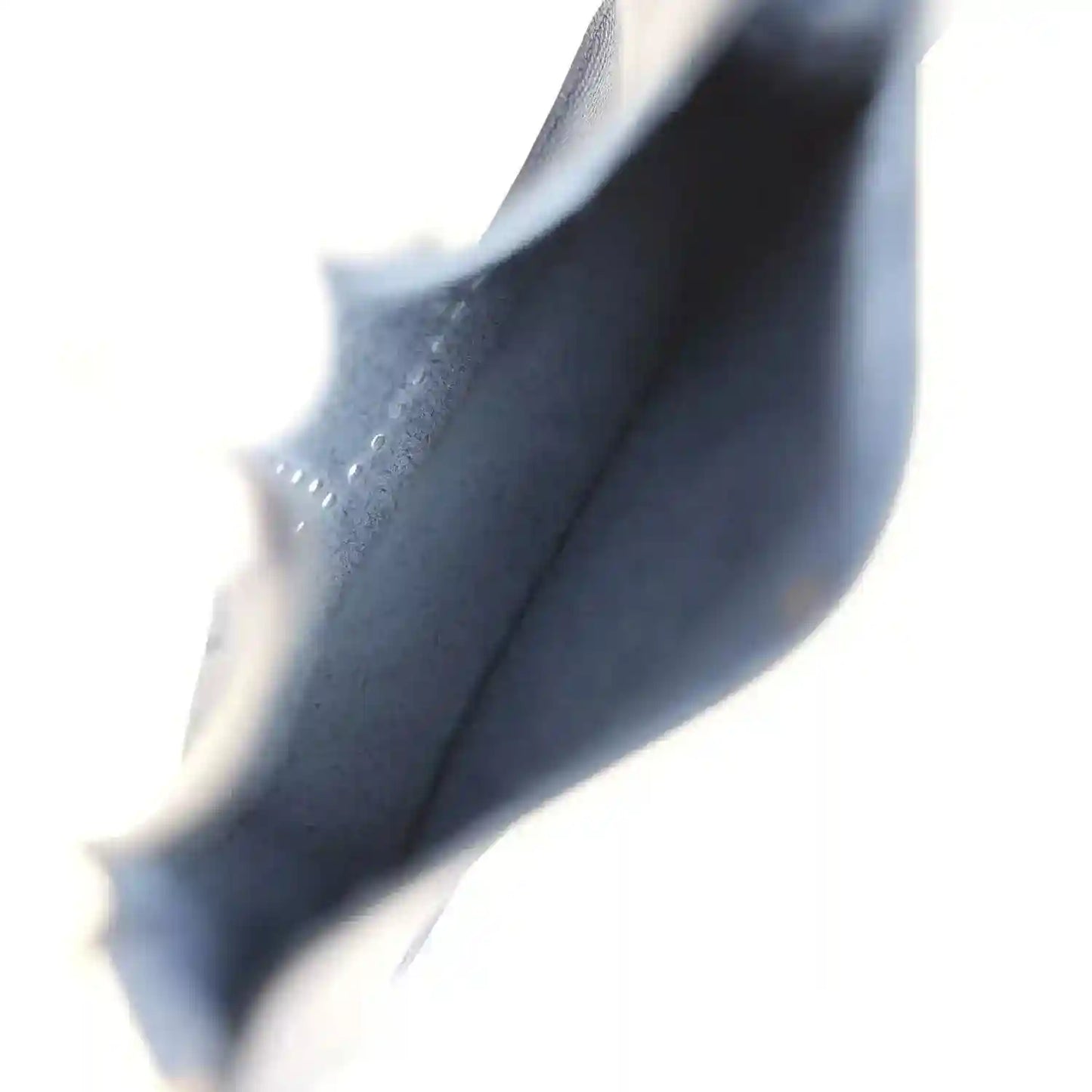 Blue leather bag edge close-up with strap and lining detail