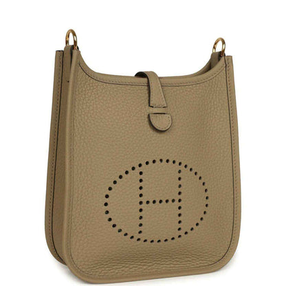 Beige pebbled leather Evelyne TPM bag front view with perforated H logo and top handle