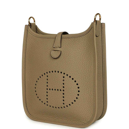Beige pebbled leather Evelyne TPM bag angled view with perforated H logo and side panel