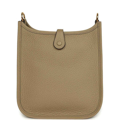 Beige pebbled leather Evelyne TPM bag front with centered loop closure tab and gold hardware