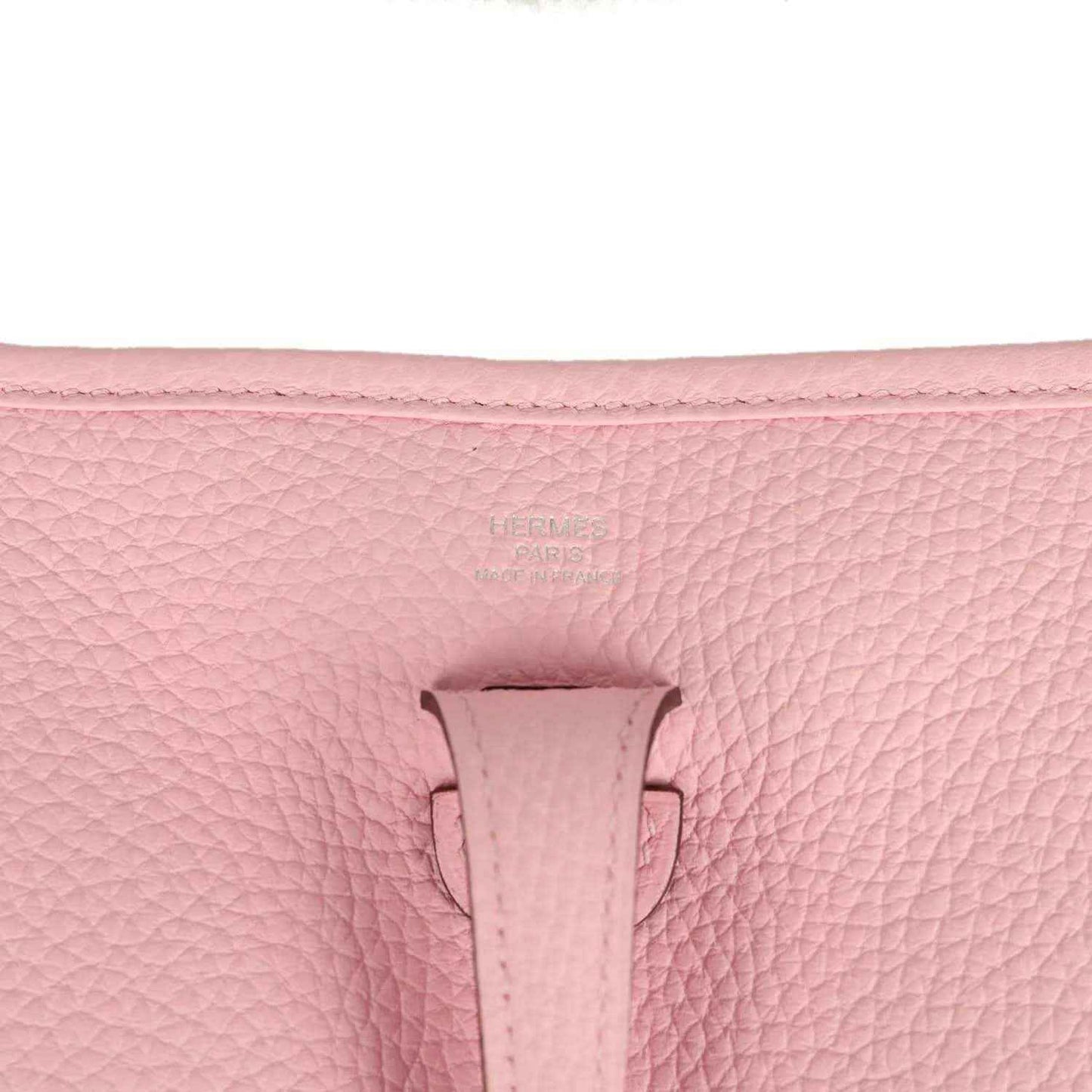 Hermes Evelyne 23 bag in rose pink leather, close-up of front tab and textured grain
