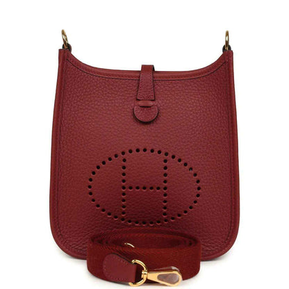 Red textured leather small bag with perforated logo, top handle, and gold hardware