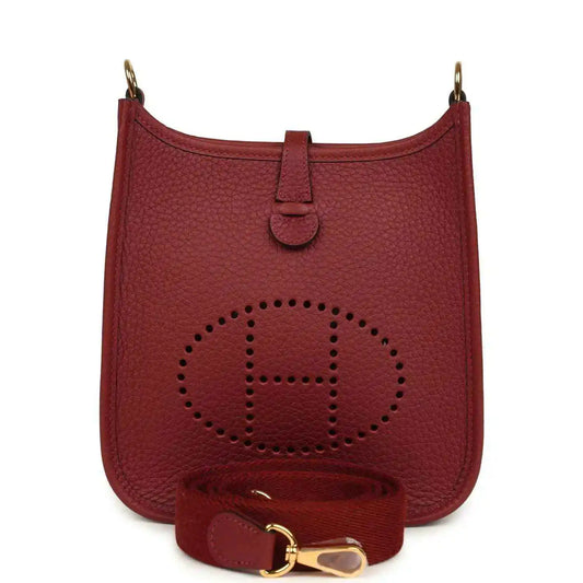 Red textured leather small bag with perforated logo, top handle, and gold hardware