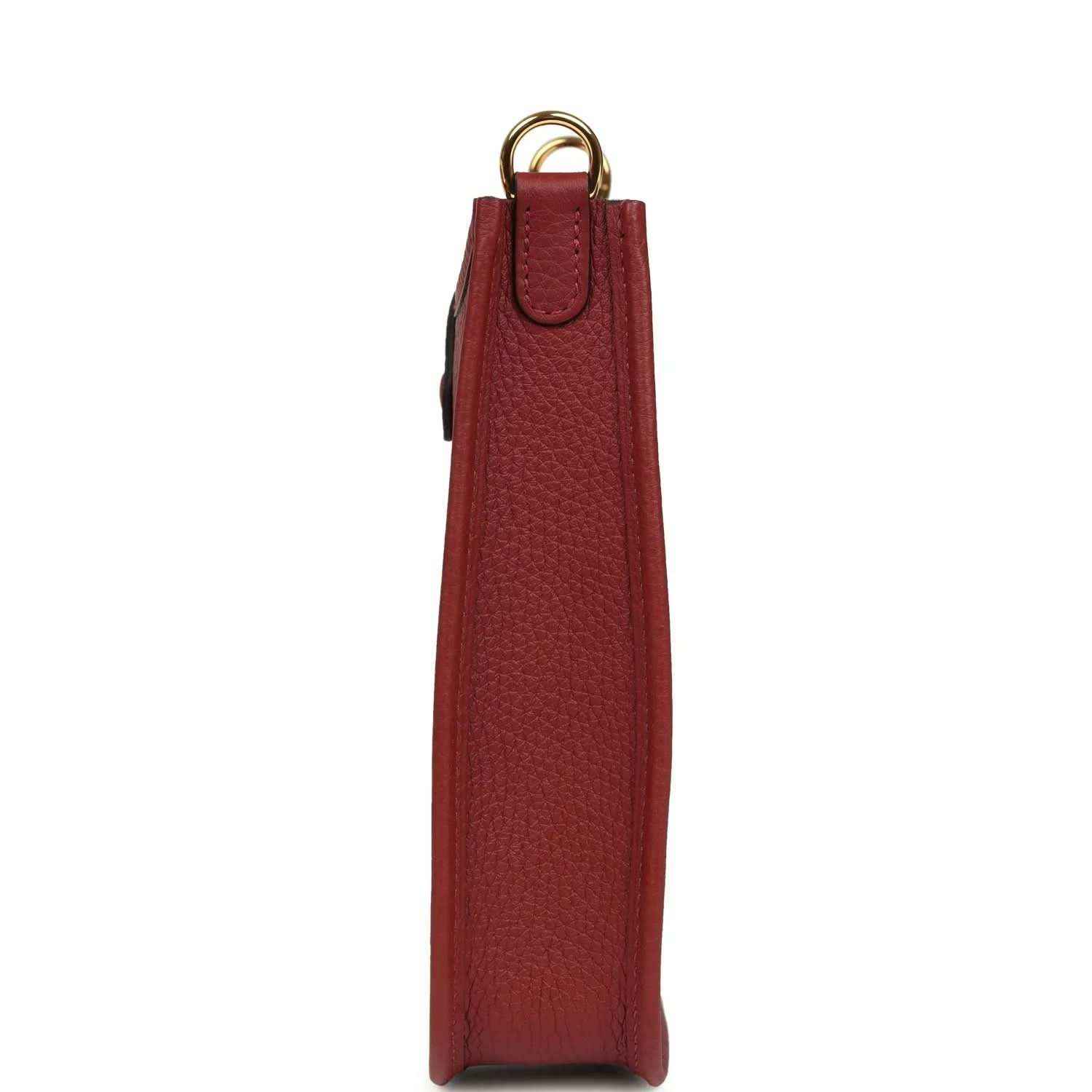 Red textured leather small bag with top handle, side view, and hanging strap loop