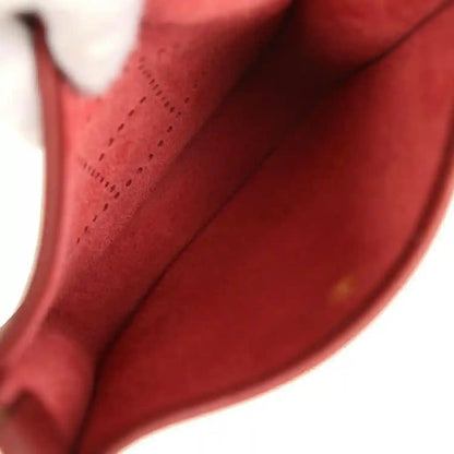 Red leather bag interior lining with visible seam and inner wall