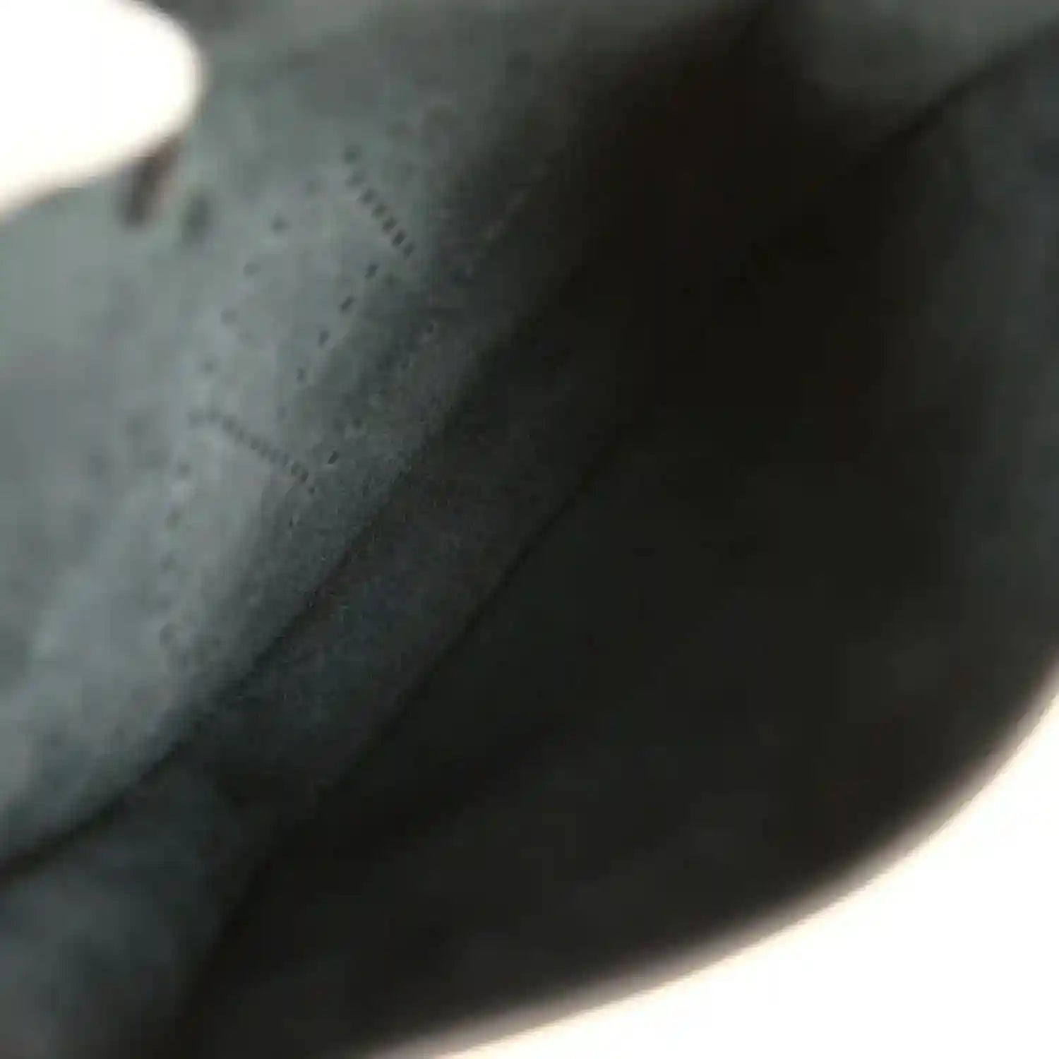 Black leather bag interior lining with smooth fabric and curved edge