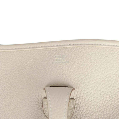 Hermes Evelyne III PM messenger bag close-up of light beige pebbled leather with Hermes stamp