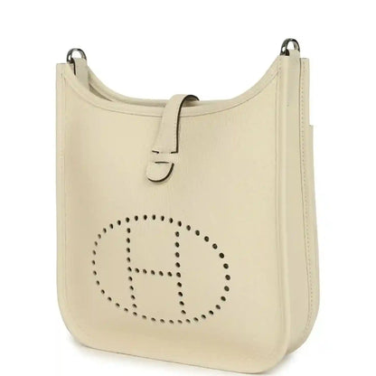 Cream leather shoulder bag with perforated logo front and top handle rings