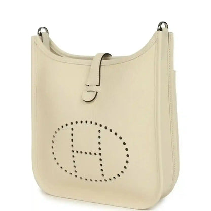 Cream leather shoulder bag with perforated logo front and top handle rings