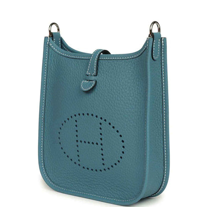 Blue denim leather mini messenger bag with perforated oval logo and side handle