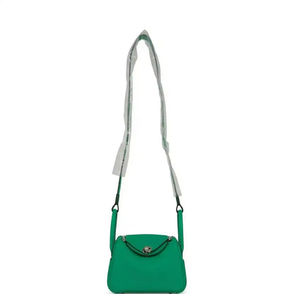 Mini green leather handbag with shoulder straps and flap front