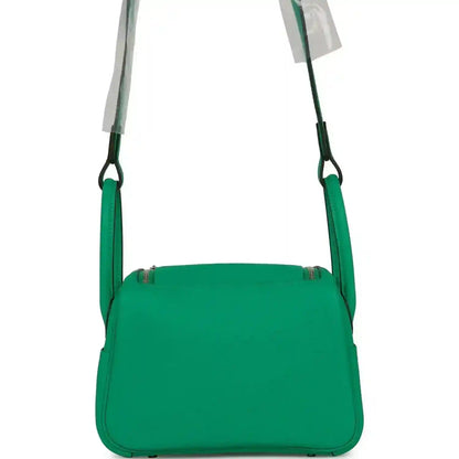 Mini green leather handbag with wide top flap and shoulder straps