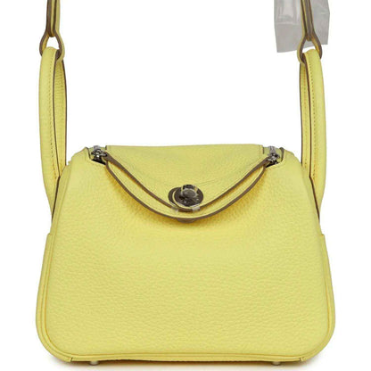 Hermes mini Lindy handbag in textured yellow leather, top flap with metal clasp.