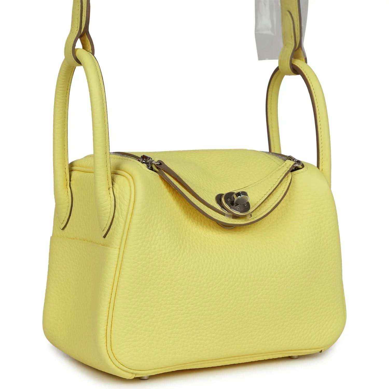 Hermes mini Lindy handbag in textured yellow leather with curved shoulder straps.