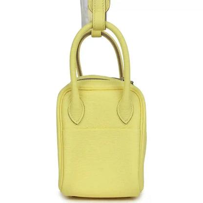 Hermes mini Lindy handbag in textured yellow leather, view of top handles.