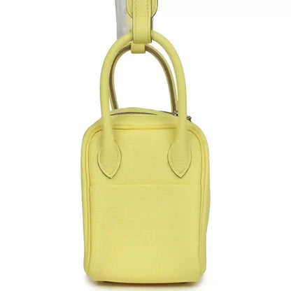 Hermes mini Lindy handbag in textured yellow leather, view of top handles.