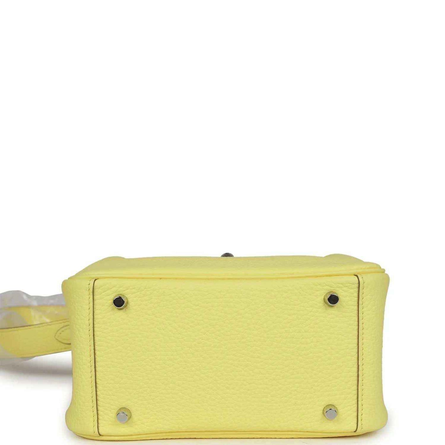 Hermes mini Lindy handbag in textured yellow leather, bottom corner with metal feet.