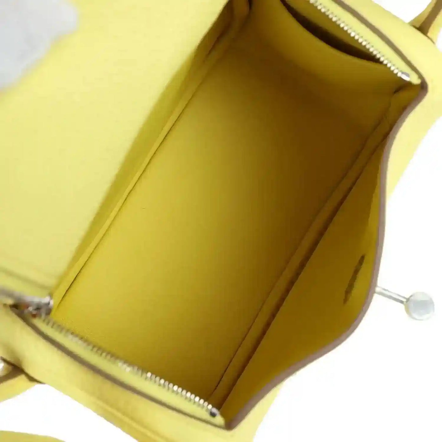 Hermes mini Lindy handbag interior in yellow leather lining with pocket opening.