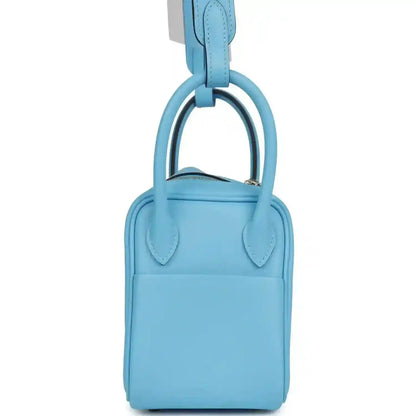 Light blue leather mini handbag with top carry handles and central seam detail