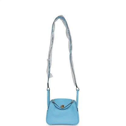 Light blue leather mini handbag with a short shoulder strap and top flap clasp