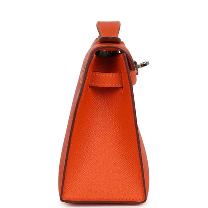 Orange Epsom leather clutch side view with top handle and flap opening