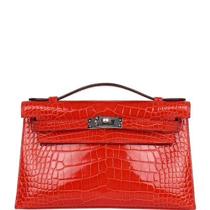 Orange crocodile-texture Kelly pochette with top handle and front clasp hardware