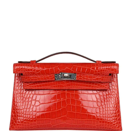 Orange crocodile-texture Kelly pochette with top handle and front clasp hardware