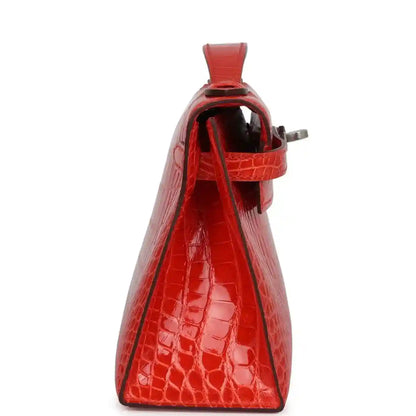 Orange crocodile-texture small bag with top handle, hinged clasp, and side opening