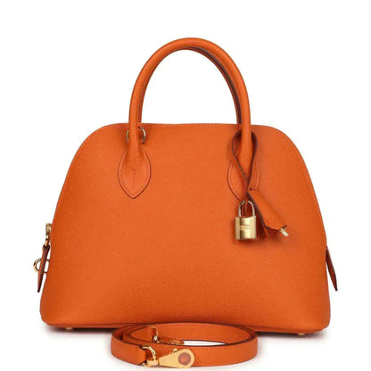 Orange leather handbag with top handles, lock charm and gold hardware, with detachable strap.