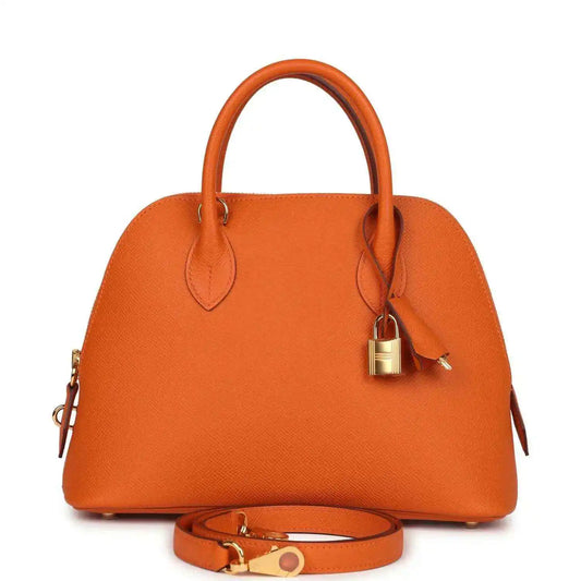 Orange leather handbag with top handles, lock charm and gold hardware, with detachable strap.
