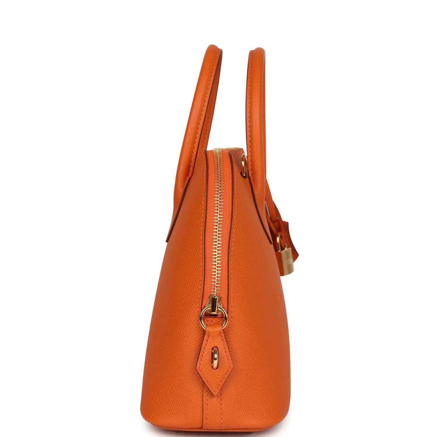 Orange leather handbag side view with zip closure, gold zipper pull, and hanging leather charm.
