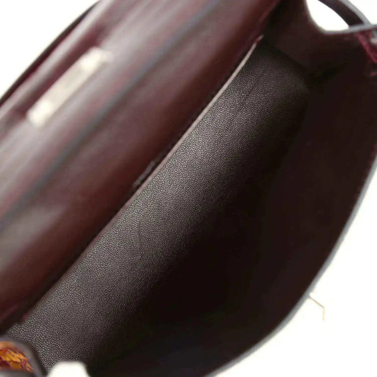 Burgundy handbag interior lining with smooth leather texture close-up