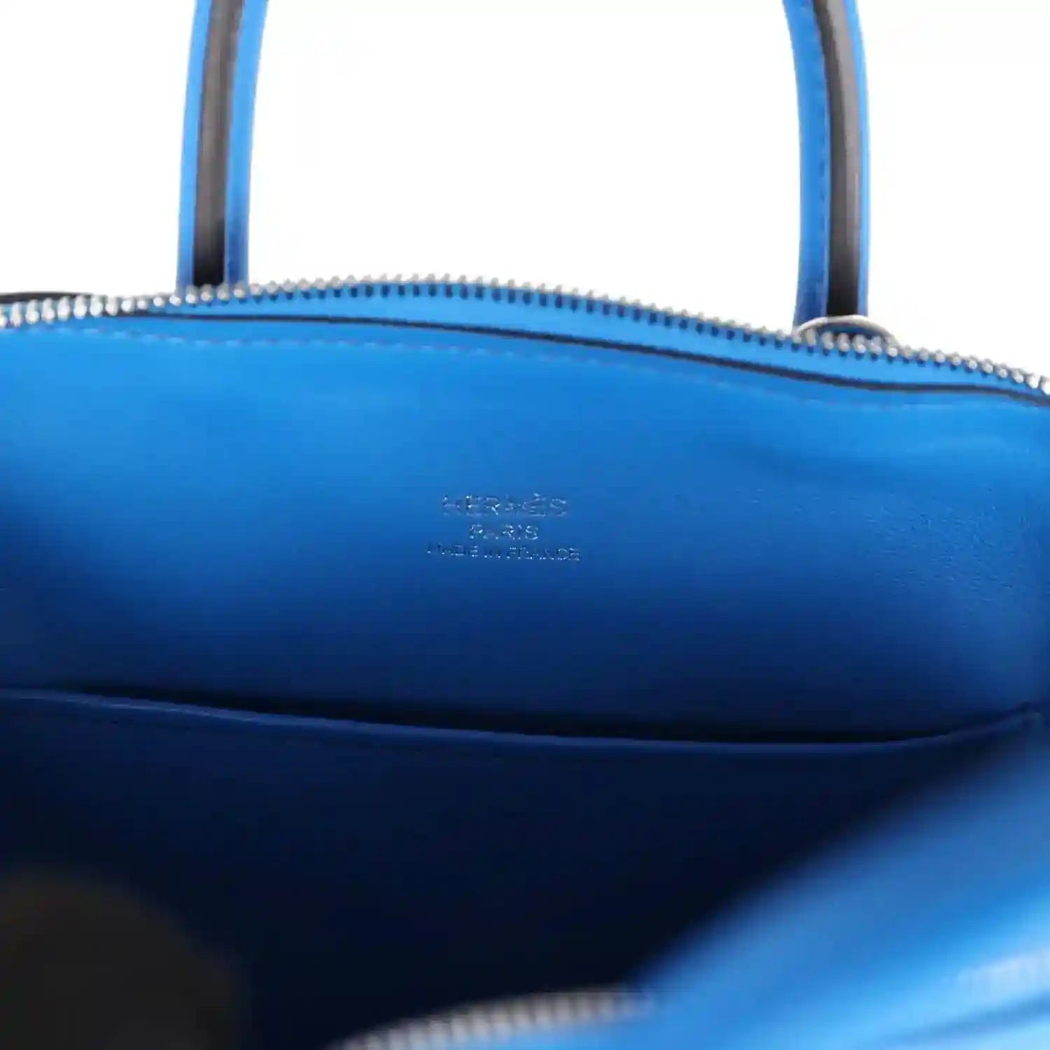 Hermes mini Bolide bag interior in bright blue leather with stamped logo and zipper trim