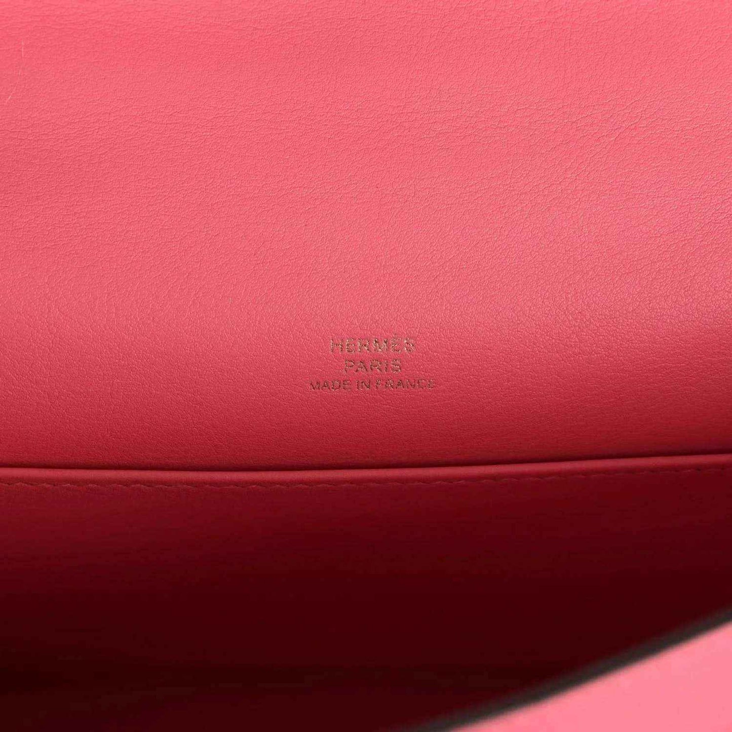 Hermes leather bag close-up with embossed Hermes mark on pink leather base