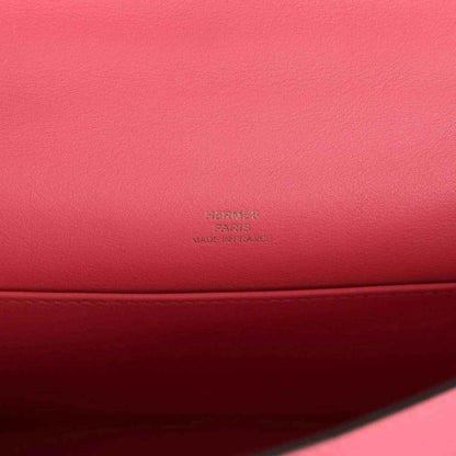 Hermes leather bag close-up with embossed Hermes mark on pink leather base