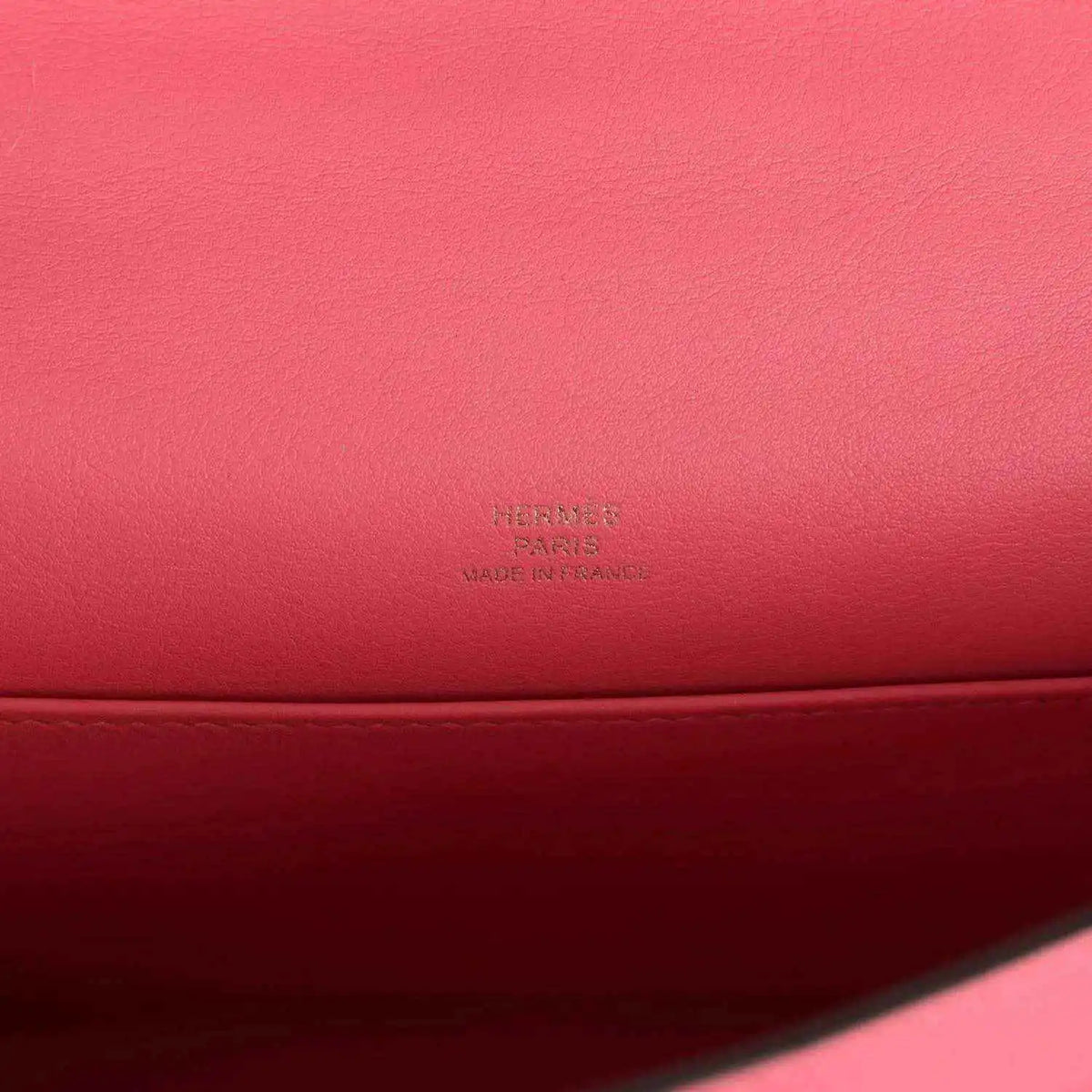 Hermes leather bag close-up with embossed Hermes mark on pink leather base