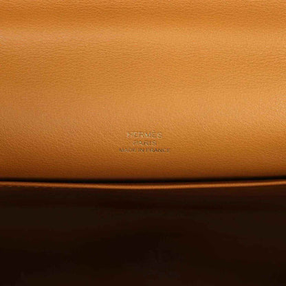 Tan leather handbag close-up with embossed Hermes logo