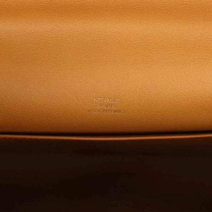 Tan leather handbag close-up with embossed Hermes logo