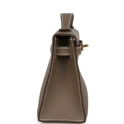 Hermes Kelly leather clutch close-up, etoupe with hanging strap loop and gold clasp